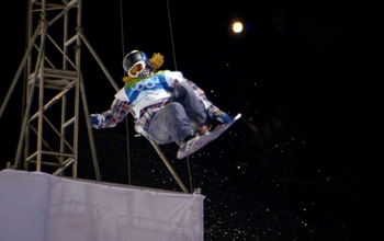 Snowboarder in the air with the moon in the background